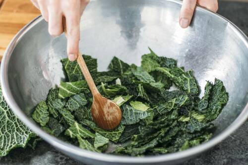 Wirsingblätter werden in einer Schüssel mariniert