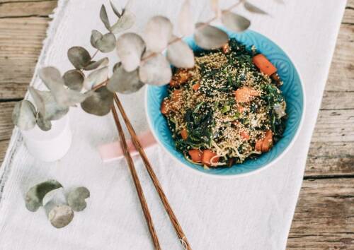 Grünkohl neu interpretiert – ganz im Asiastyle mit Nudeln zubereitet, daneben Stäbchen. Von oben fotografiert.