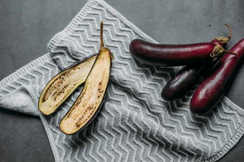 Auberginen aufgeschnitten und Ganz vor dunklerem Hintergrund.