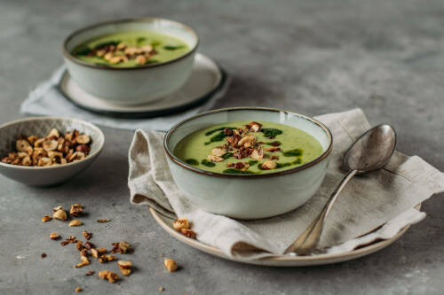 Selbstgemachte Bärlauch-Blumenkohl-Suppe in einer hellblauen Schale.