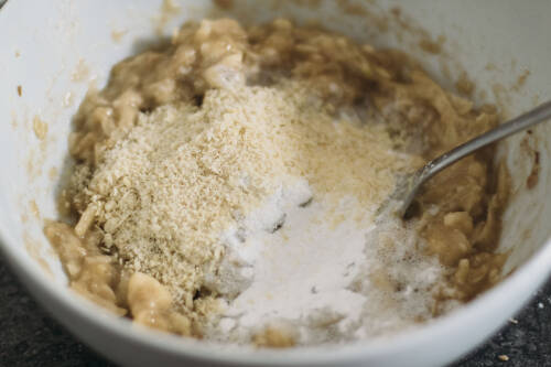 Banane mit Apfel und Sojamehl in Schüssel vermengt.