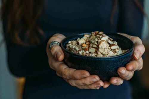 Birchermüsli mit Milch in der Hand