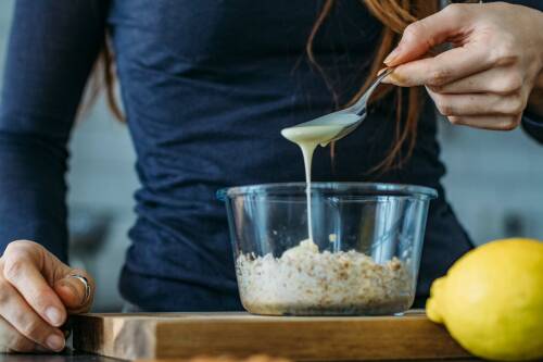 Birchermüsli - Zitronensaft und Kondensmilch über die Haferflocken geben.