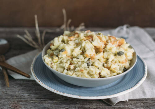 Böhmischer Kartoffelsalat in einer Schüssel, von oben-seitlich fotografiert.