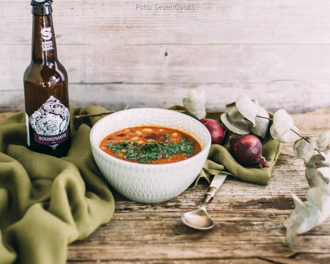 Beschwipste Bohnen dekoriert in einer Schale mit einer Flasche Bier