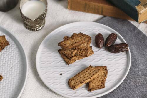 Dattelkekse ohne Zucker auf weißem Teller vor hellem Hintergrund.