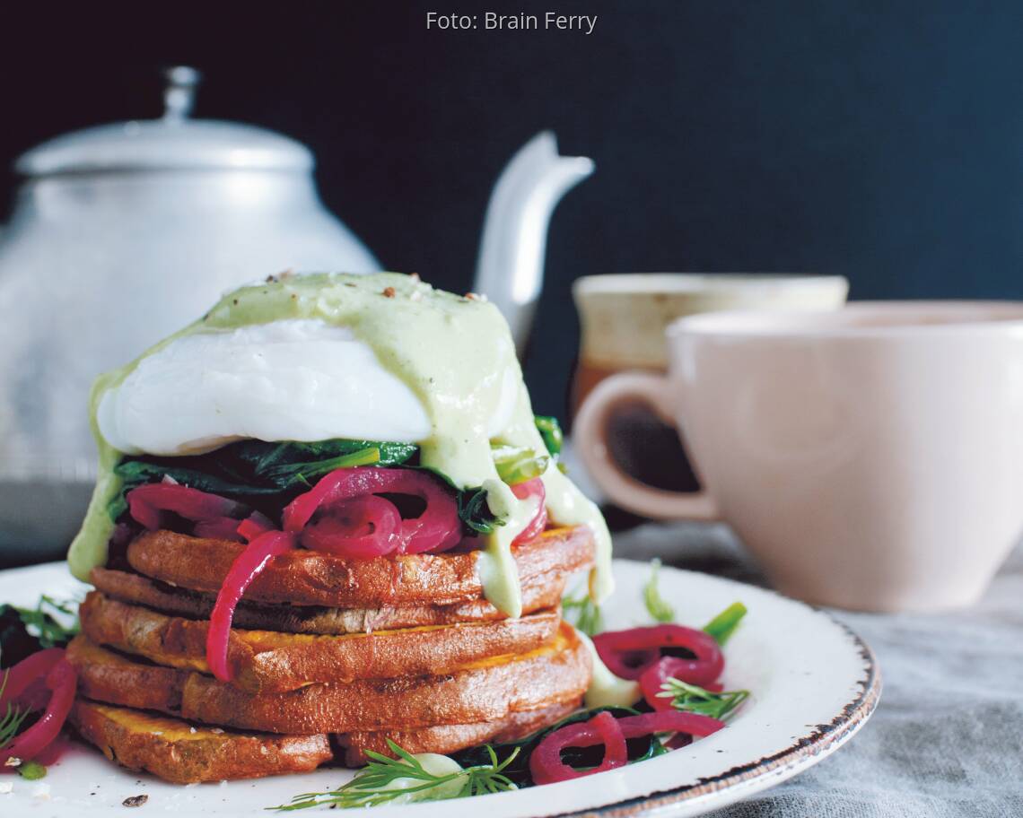 Eggs Benedict aufeinander gestapelt mit Avocado Topping