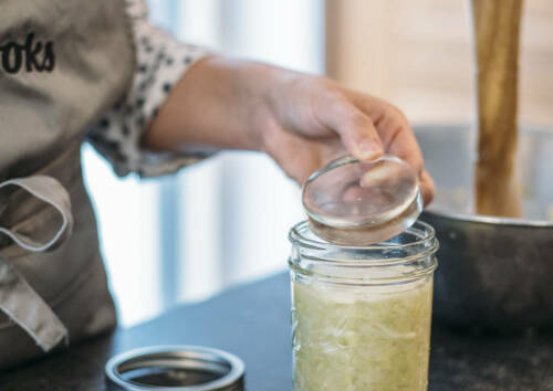 Ein Glas-Stein wird zum Beschweren auf das Kraut im Glas gelegt.