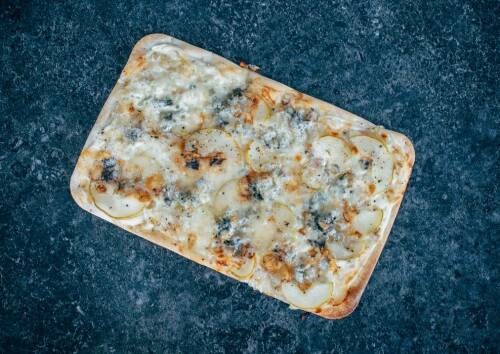 Süß-herzhafter Flammkuchen mit Birne und Gorgonzola, von oben fotografiert.