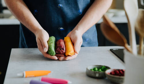Drei Rollen gefärbtes Marzipan: grün, rot und orange.
