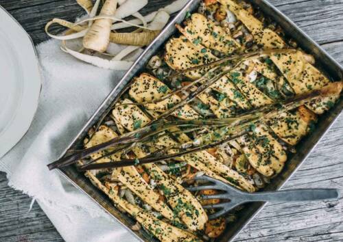 Gebackene Pastinaken mit intensiven Gewürzen in einer Auflaufform, von oben fotografiert.