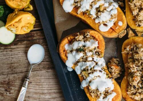 Gefüllter Butternuss-Kürbis auf dem Blech, von oben fotografiert.