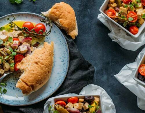 Gegrillter Tofu mit Fladenbrot auf Tellern vor dunklem Hintergrund.