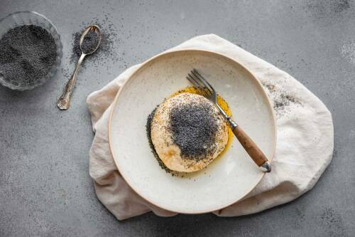 Germknödel in weißem Teller vor hellem Hintergrund.
