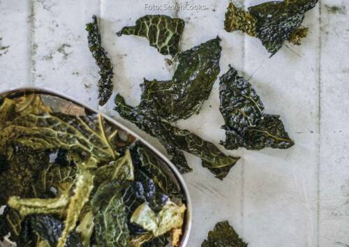 selbst gemachte Chips aus Wirsing; leuchtend grün und knusprig auf Holztisch