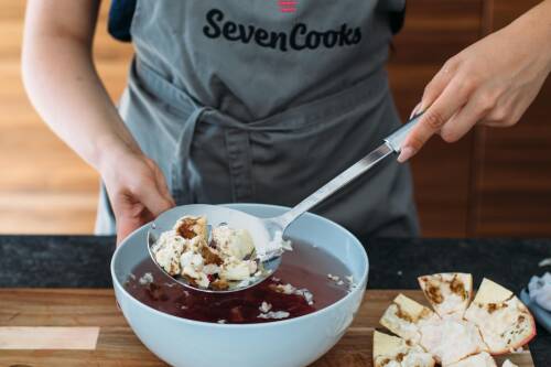 Abschöpfen der Trennhäute des Granatapfels mit einer Schaumkelle
