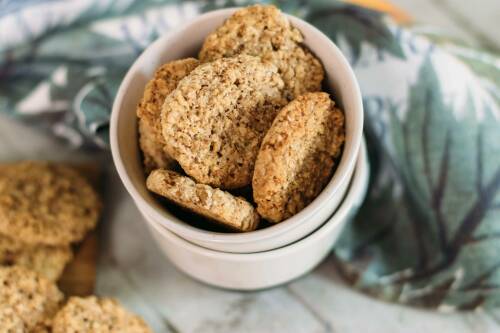 Haferflockencookies in Schüssel vor dunklem Hintergrund.
