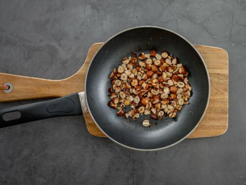 Gehackte Haselnüsse in einer Pfanne.