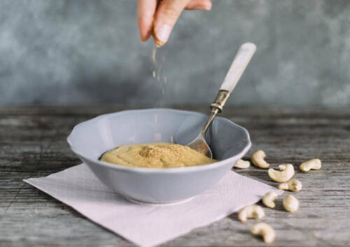 Selbstgemachter Hefeschmelz zum Überbacken. Daneben Cashew-Nüsse, von der Seite fotografiert.