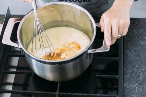 Hefeschmelz in Topf mit Händen und Gewürzen.