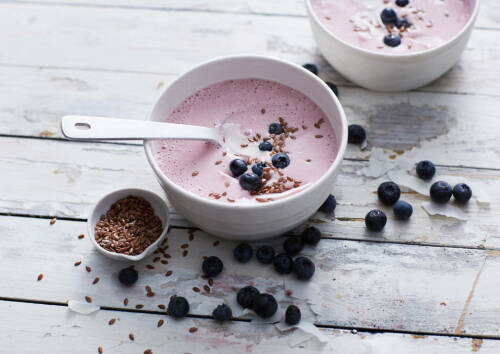 Himbeer-Smoothie-Bowl mit Blaubeeren von oben fotografiert.