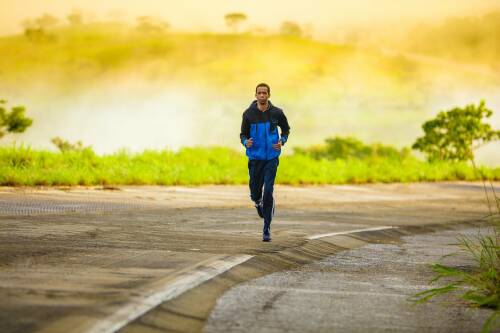 Jogger auf Straße vor Sonnenaufgang.