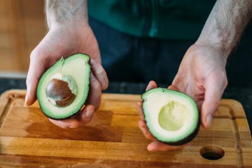 Ist der Avocadokern giftig? Hier siehst du zwei Avocadohälften, eine mit und eine ohne Kern.