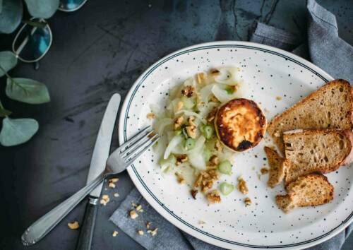 Ziegenkäse und Fenchel - frisch karamellisiert mit Honig - auf einem Teller angerichtet.