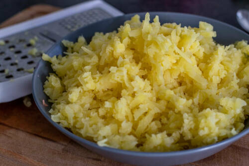 Kartoffelabrieb in Schüssel vor hellem Hintergrund.