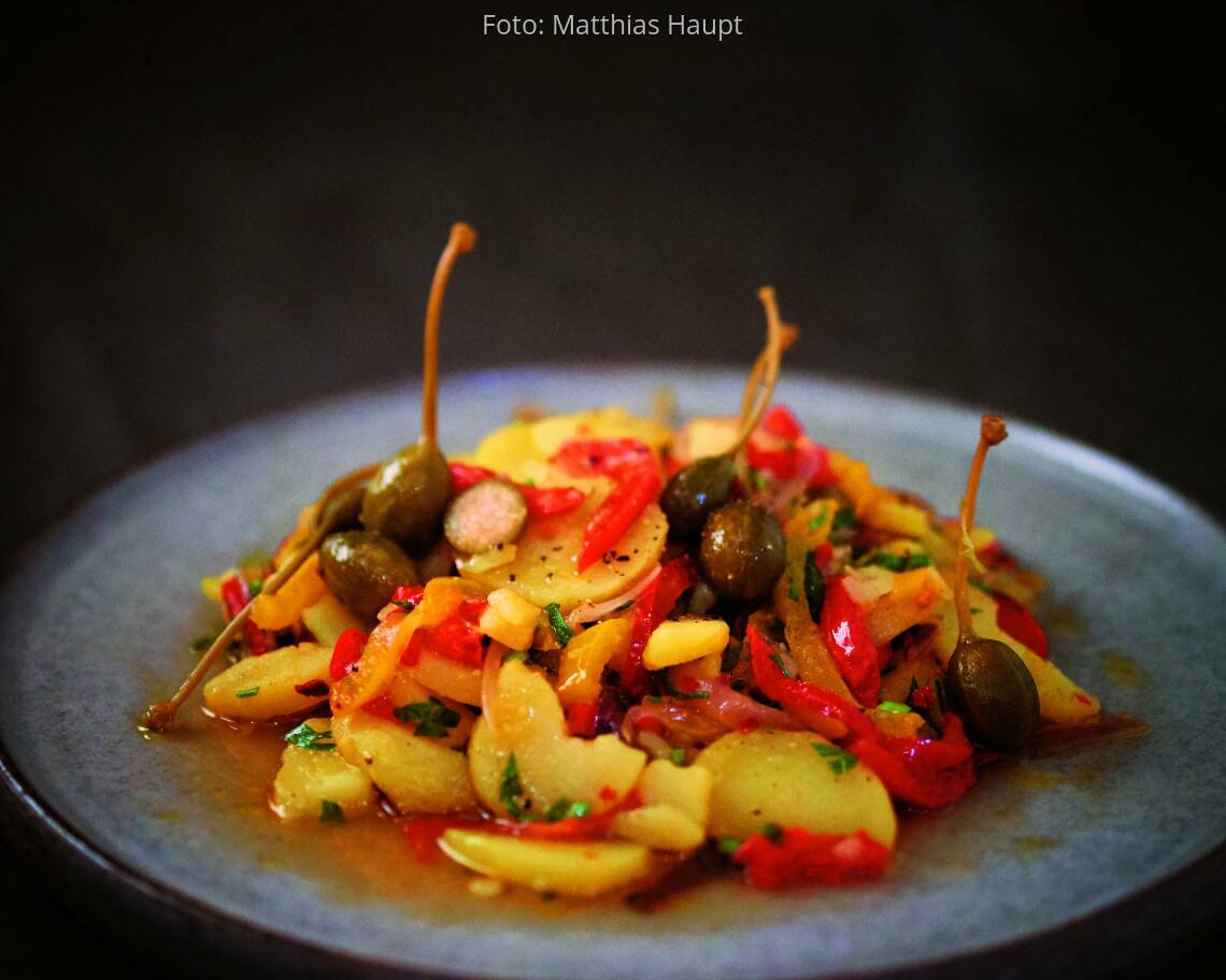 Kartoffelsalat mit Paprika und Kapern auf einem Teller
