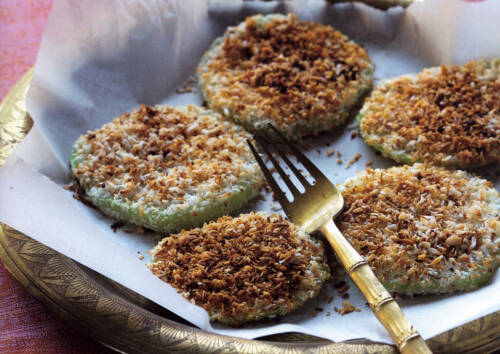 Mit Kokos panierter Kohlrabi auf einem Teller, dazu eine Gabel. Von oben-seitlich fotografiert.