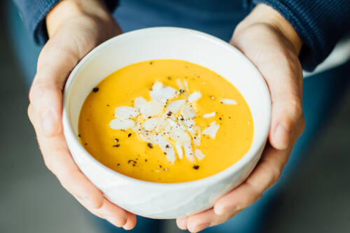 Frisch gemachte Kürbissuppe In einer weißen Schale mit Kokosflocken