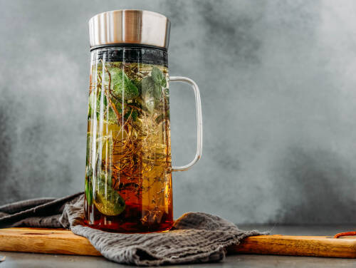 Kräuter Limonade in Karaffe vor hellem Hintergrund.