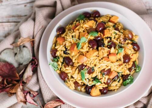 Herbstlicher Nudelsalat mit Trauben, Kürbis und Haselnüssen in einer Schüssel von oben fotografiert.