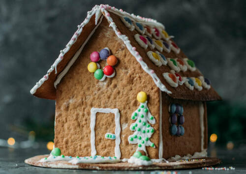 Lebkuchenhaus aus selbstgebackenen Lebkuchen mit Zuckerguss und bunten Zuckerperlen