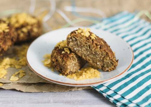 Linsenbratlinge auf einem Teller, von vorne fotografiert.