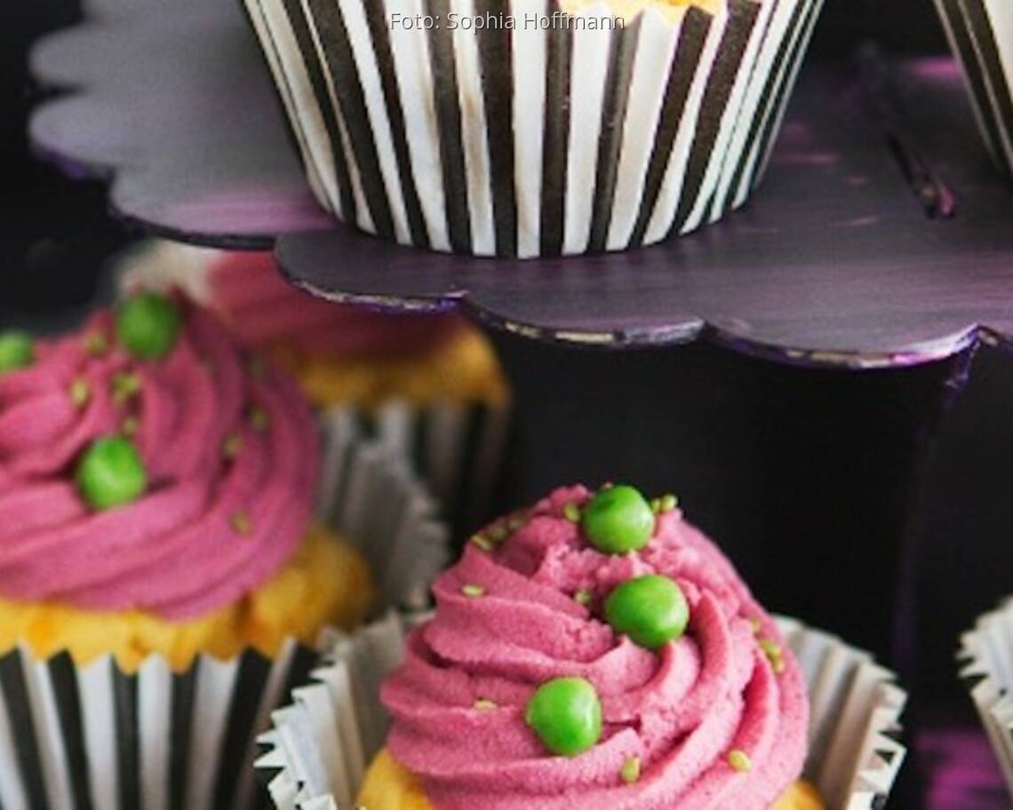Herzhafte Cupcakes in gestreiftem Förmchen mit pinken Topping und Erbsen als Deko