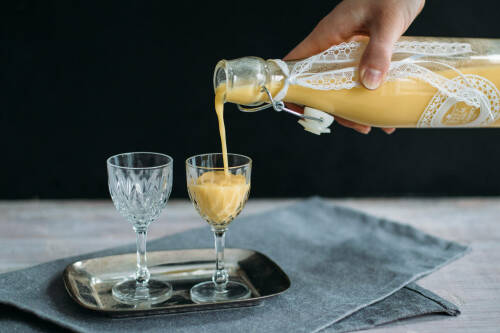 Selbst gemachter Maracuja-Likör wird in ein Glas eingeschenkt.
