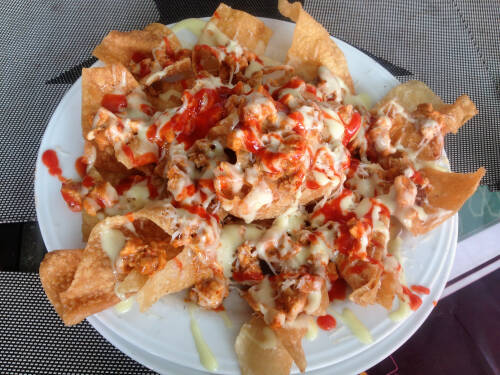 Ein typisch mexikanisches Essen sind Nachos mit Käse und Tomatensauce, von oben fotografiert.