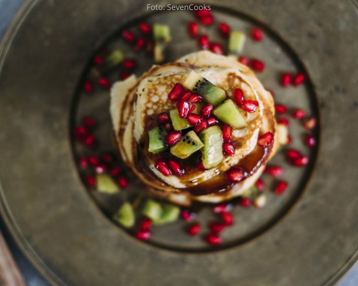 Stapel Pancakes von oben mit Kiwi und Granatapfel