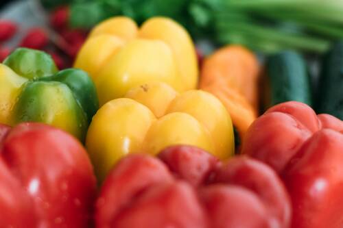 Grüne, gelbe und rote Paprika nebeneinander.