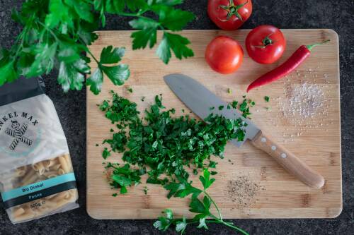 Fein gehackte Petersilie auf einem Holzbrett.