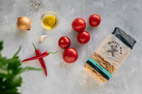 Alle Zutaten für Penne all'arrabbiata: Zwiebel, Knoblauch, Olivenöl, Tomaten, Petersilie, Pfeffer, Salz, Penne