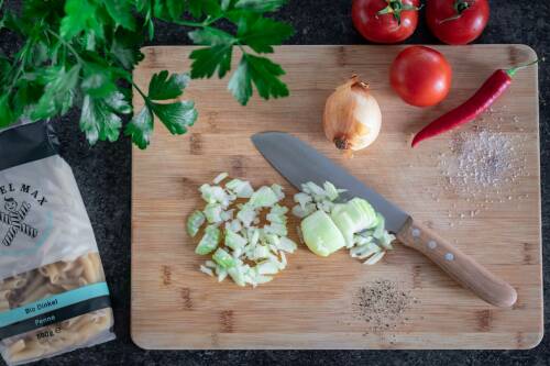 Gewürfelte Zwiebeln auf einem Holzbrett.
