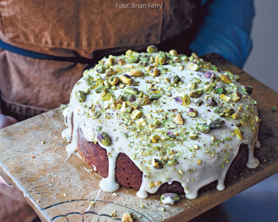 Pistazienkuchen mit weißem Guss und vielen gehackten Pistazien darauf