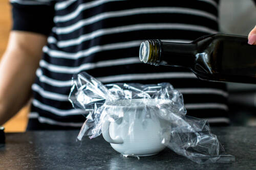 Wenn du die Tasse mit Frischhaltefolie ausgelegt hast, gieße etwas Öl hinein. Dies hilft dir später dabei, das Ei leichter aus der Folie zu lösen.