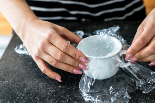 Du benötigst eine kleine Tasse, die du mit Frischhaltefolie auslegen kannst. In diese kommt später dein Ei.