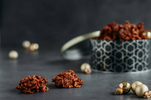 Puffreis-Schoko-Crossies in Keksdose vor dunklem Hintergrund.