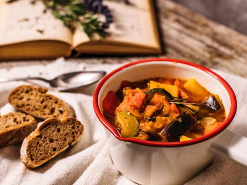 Der französische Klassiker mit leckerem Gemüse in einem kleinen Topf, dazu gibt es dunkles Baguette. Von oben fotografiert.