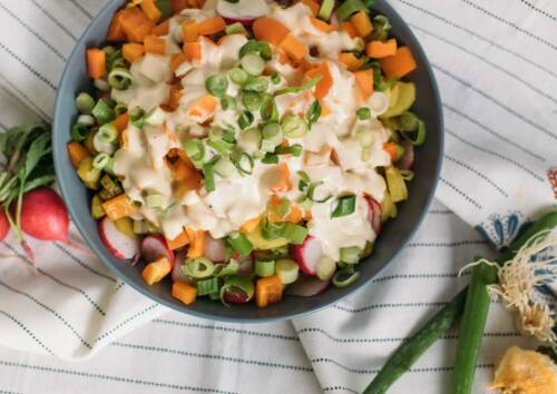 Herrlich bunter Kartoffelsalat mit Karotten, Radieschen und Lauchzwiebeln. Von oben fotografiert.
